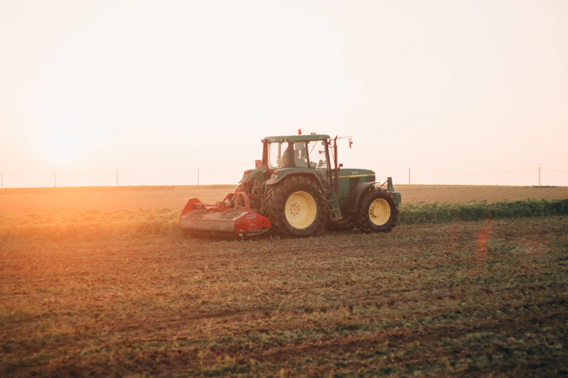 Rode tractor op bruin akkerland