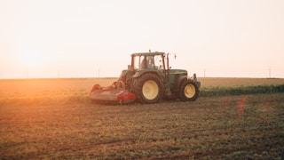 red tractor on brown field during daytime