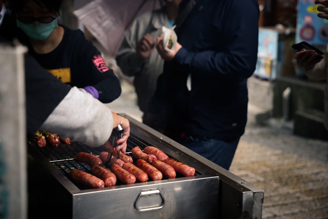 person in black jacket holding red chili,