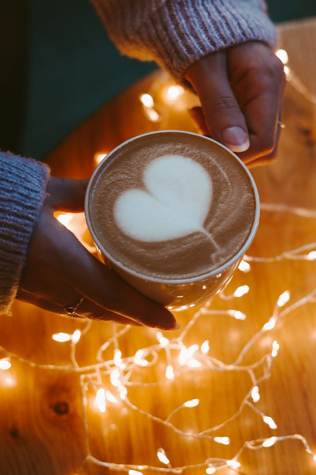 person holding white ceramic mug with white liquid