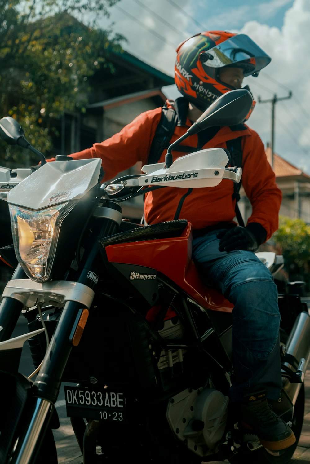 man in orange jacket riding black motorcycle