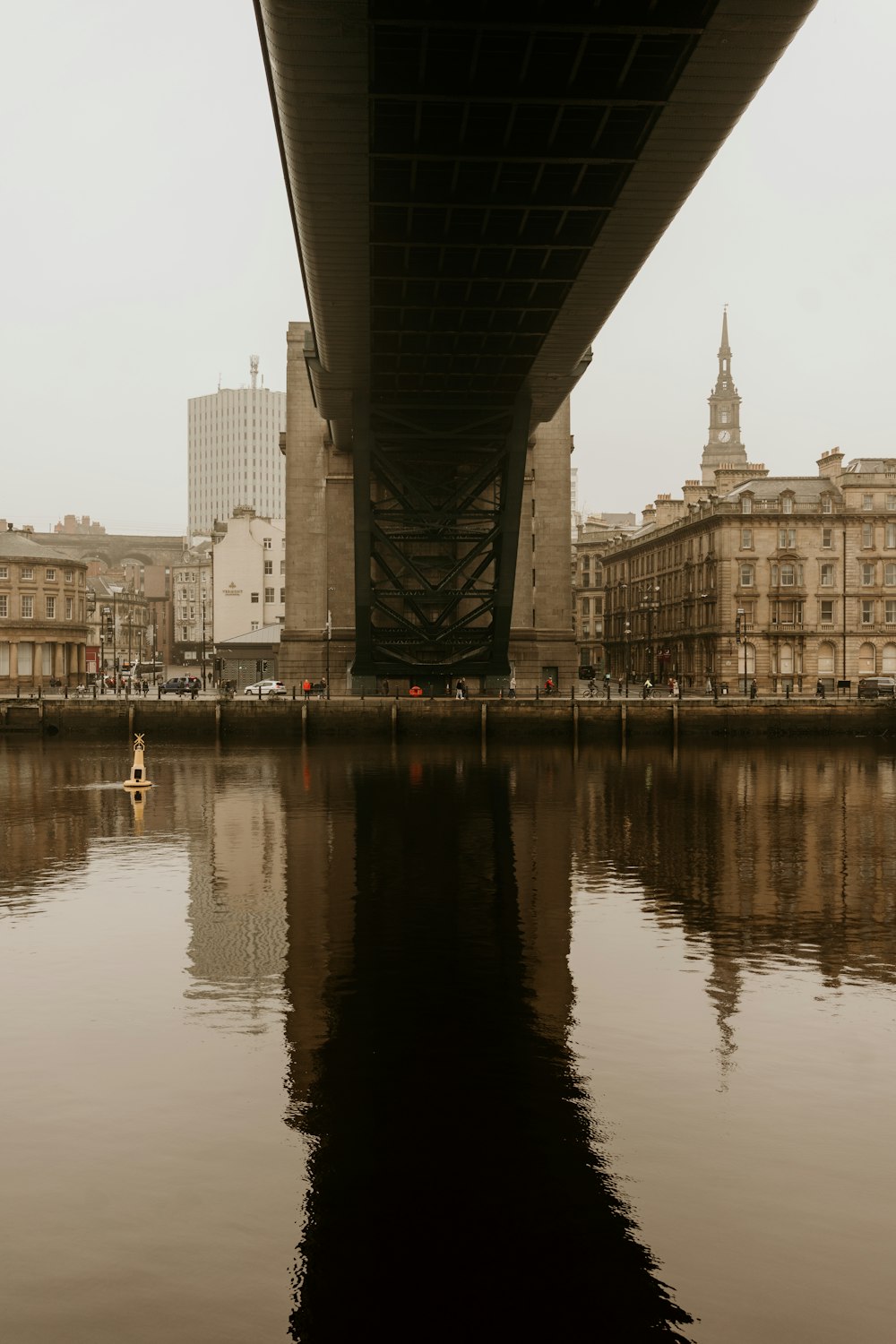 body of water near bridge and buildings during daytime