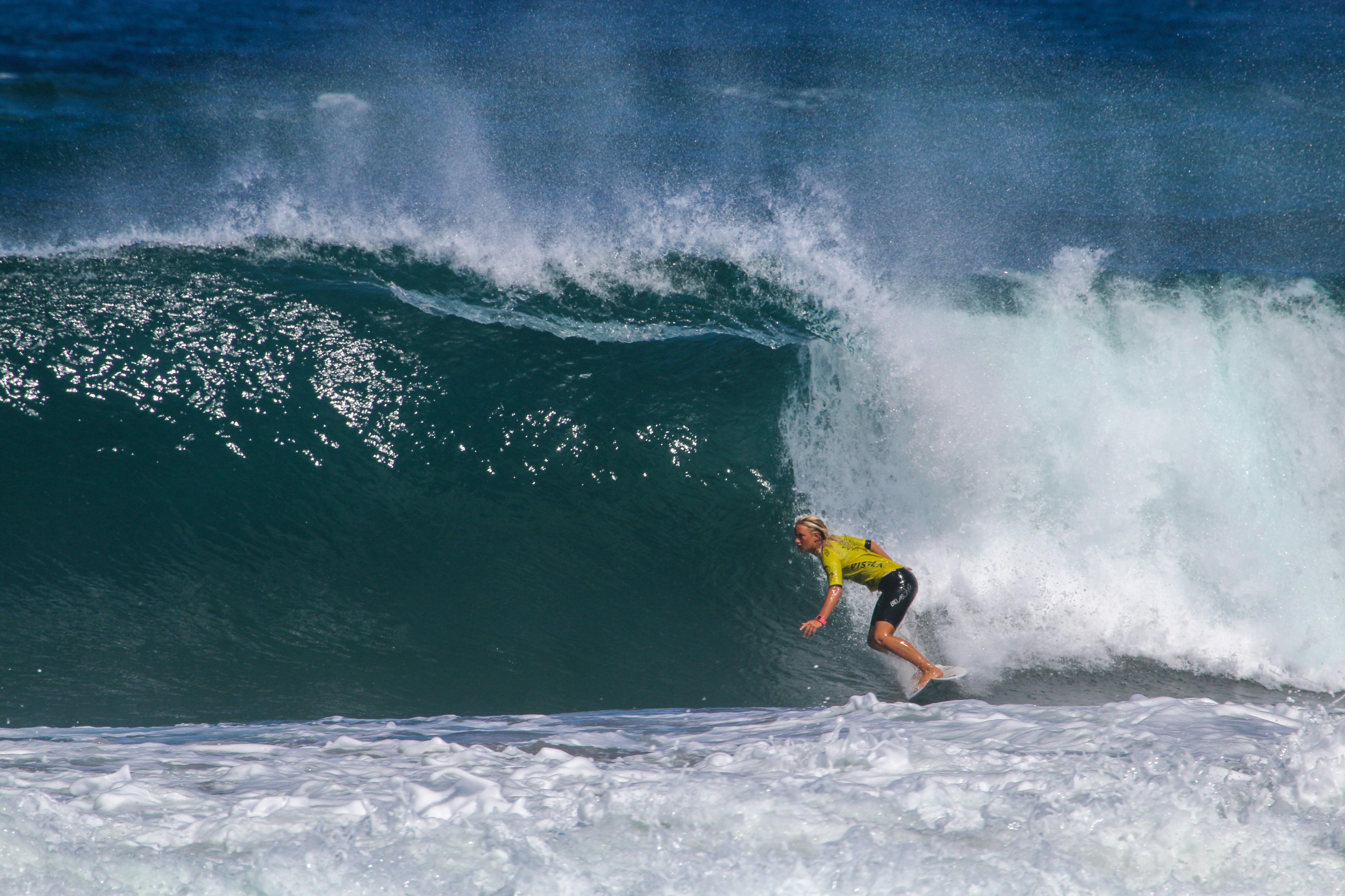 man in yellow shirt and black shorts surfing on sea waves during daytime