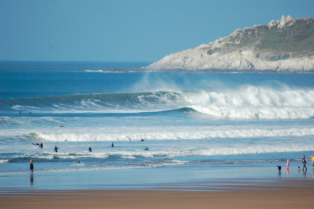 people surfing on sea waves during daytime