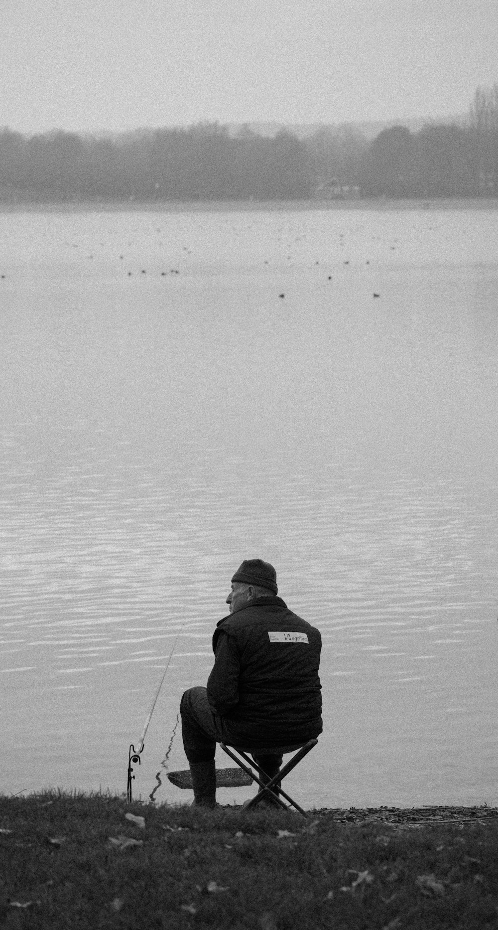 man in black hoodie fishing on water