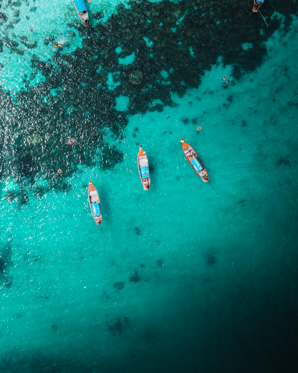 vista aérea do barco branco e vermelho no corpo de água durante o dia