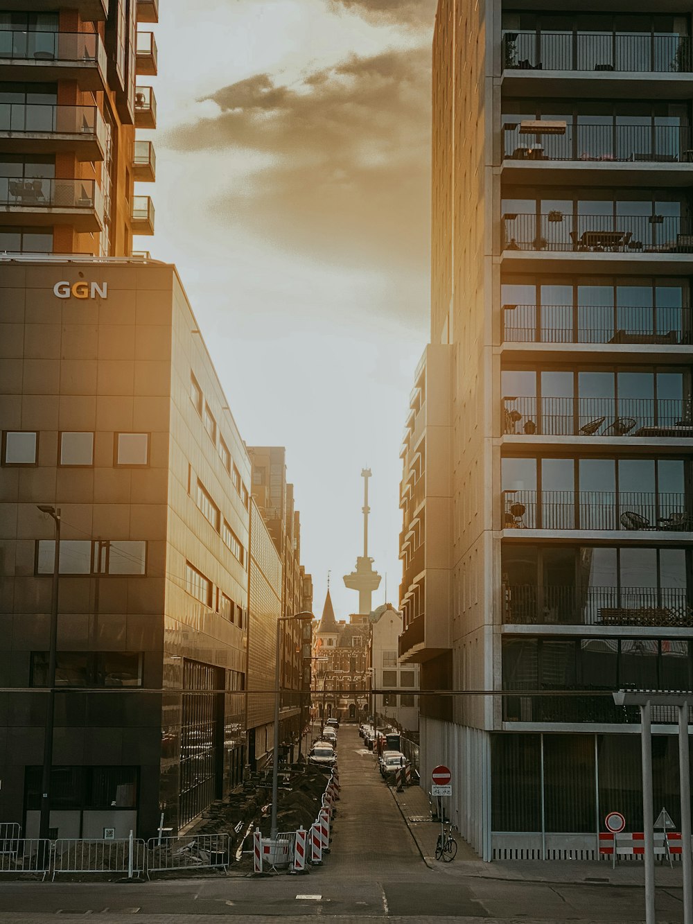 cars parked beside the road near high rise buildings during daytime