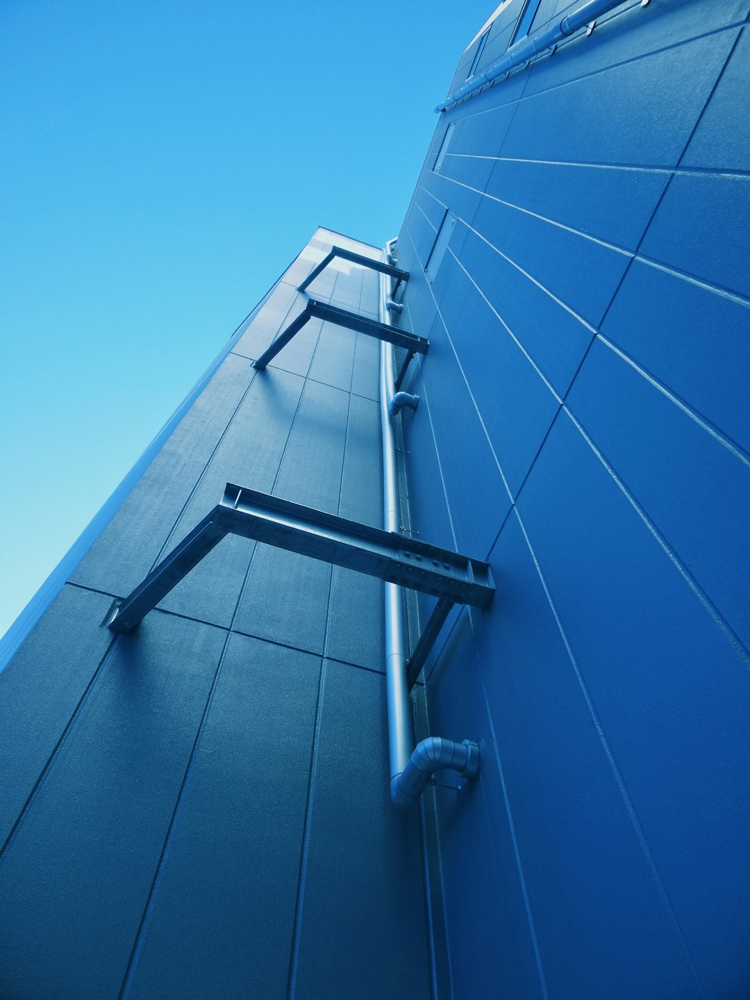 white metal ladder on blue wall