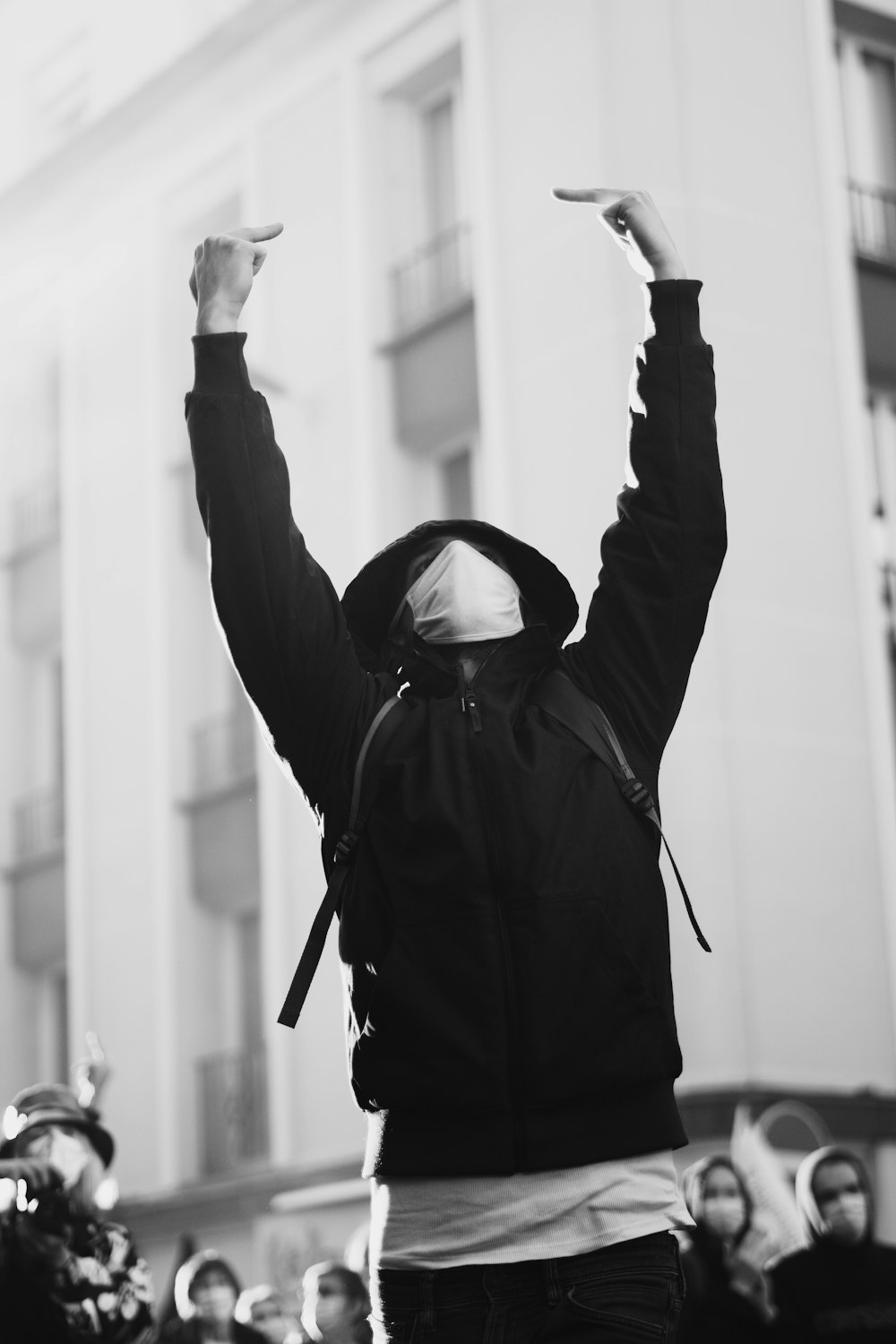 man in black jacket raising his hands