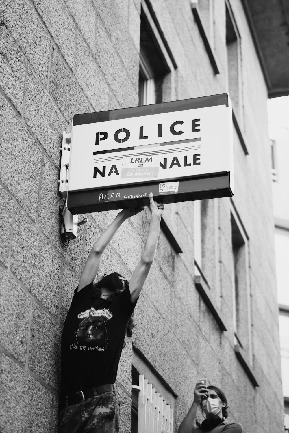 grayscale photo of woman in black shirt and pants jumping on the street