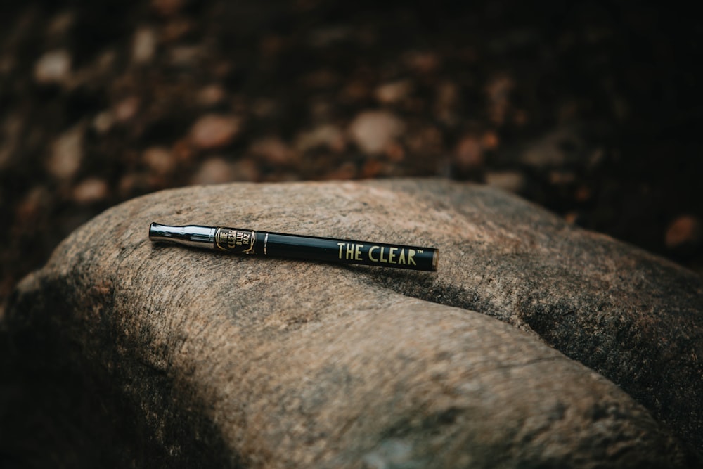 black and silver pen on gray rock