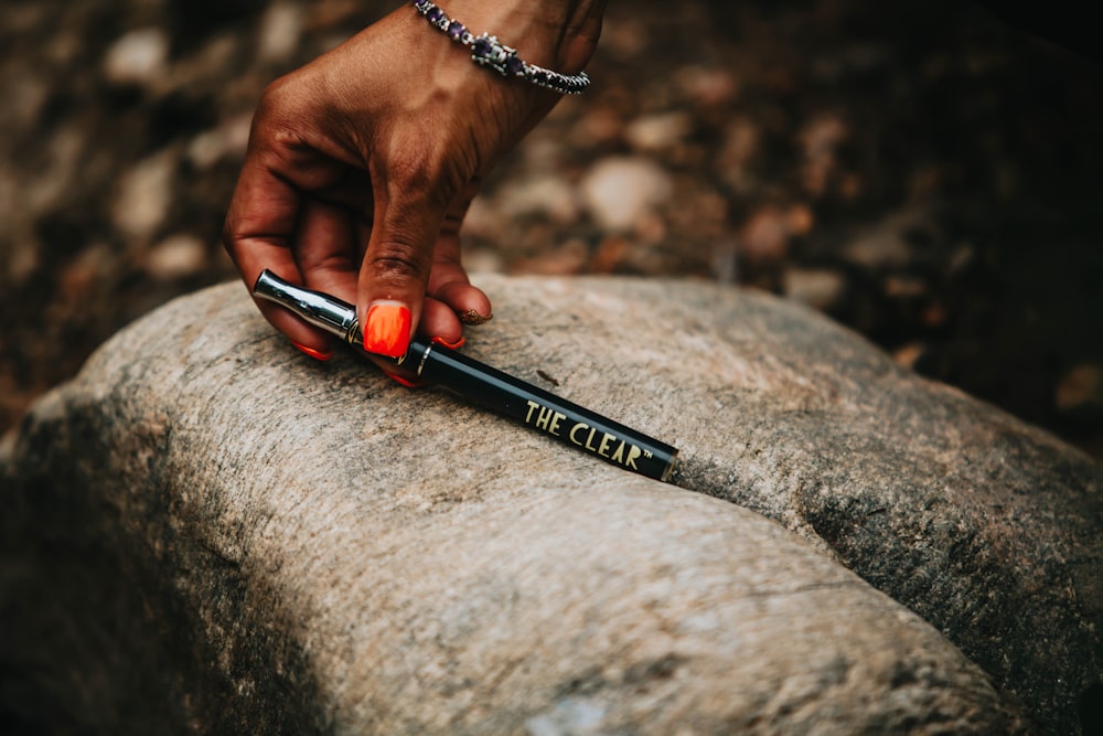 person holding black and red click pen