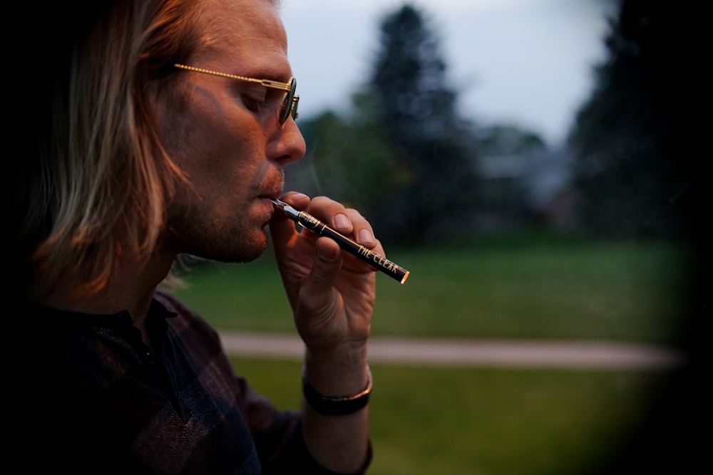 man in black framed eyeglasses smoking