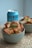 A ceramic bowl filled with golden-brown fried tofu pieces garnished with chopped green onions is in the foreground. Another similar bowl is partially visible to the right, holding more tofu. A blue can of Brewdog beverage with a noticeable logo is placed behind the bowls. The setting conveys a casual dining or snacking environment.