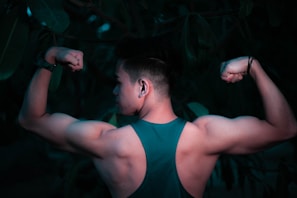 Close-up of a fit person flexing their arm muscles outdoors