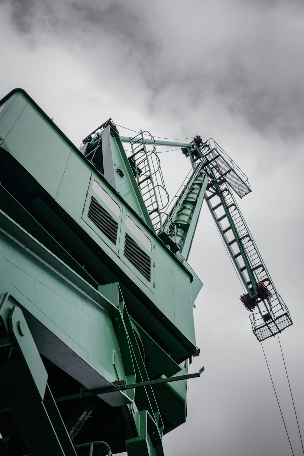 green and white crane under cloudy sky