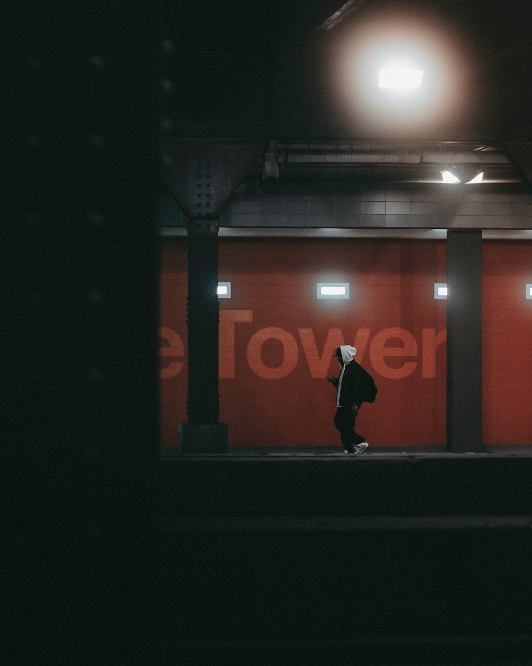 man in black jacket standing in front of red and white wall