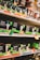 Shelves filled with various types of boxed LED light bulbs are visible, prominently featuring the NOMA brand. The boxes are black with green accents and display images of light bulbs and energy efficiency ratings. Price tags and product information are visible on the shelf edges.