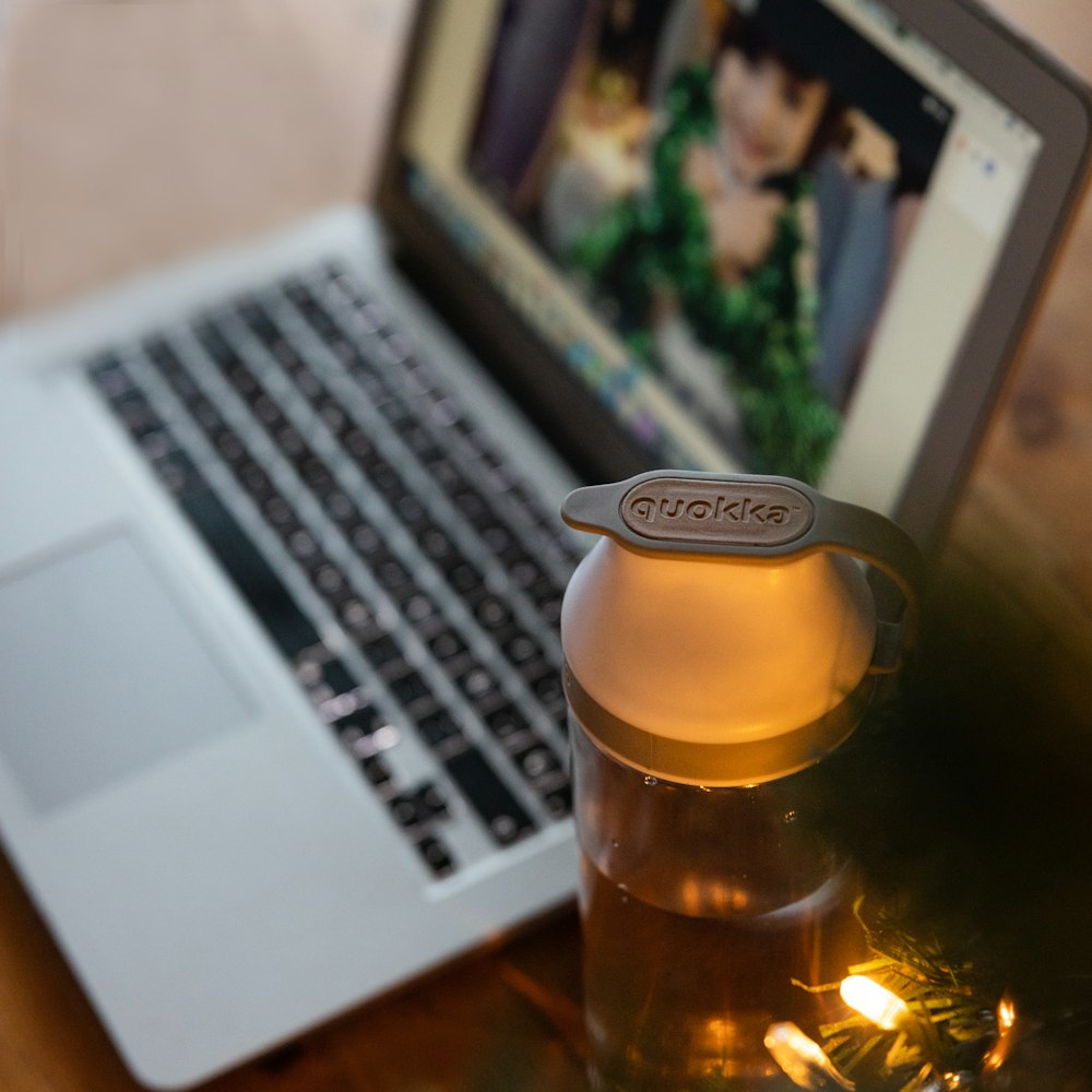 clear glass bottle beside macbook pro