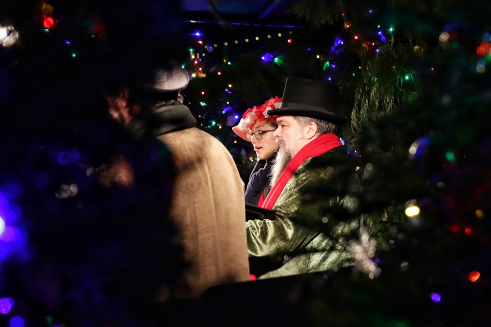 Hombre y mujer de pie cerca del árbol de Navidad