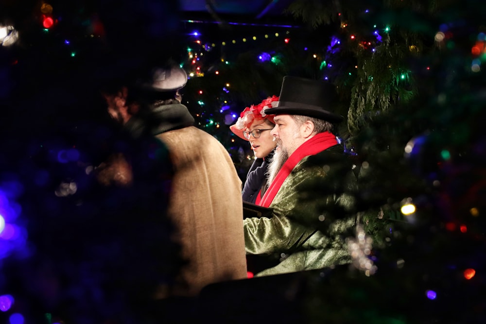 man and woman standing near christmas tree