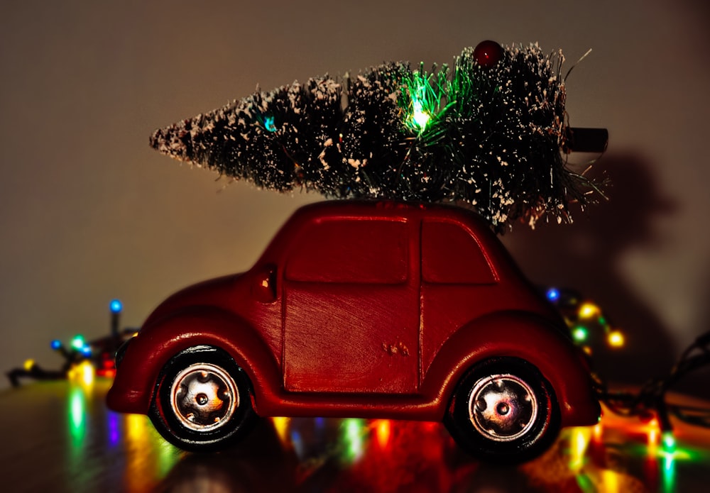 red volkswagen beetle parked beside green christmas tree