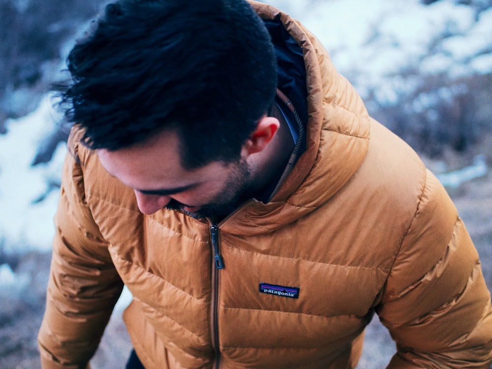 man in brown jacket looking down