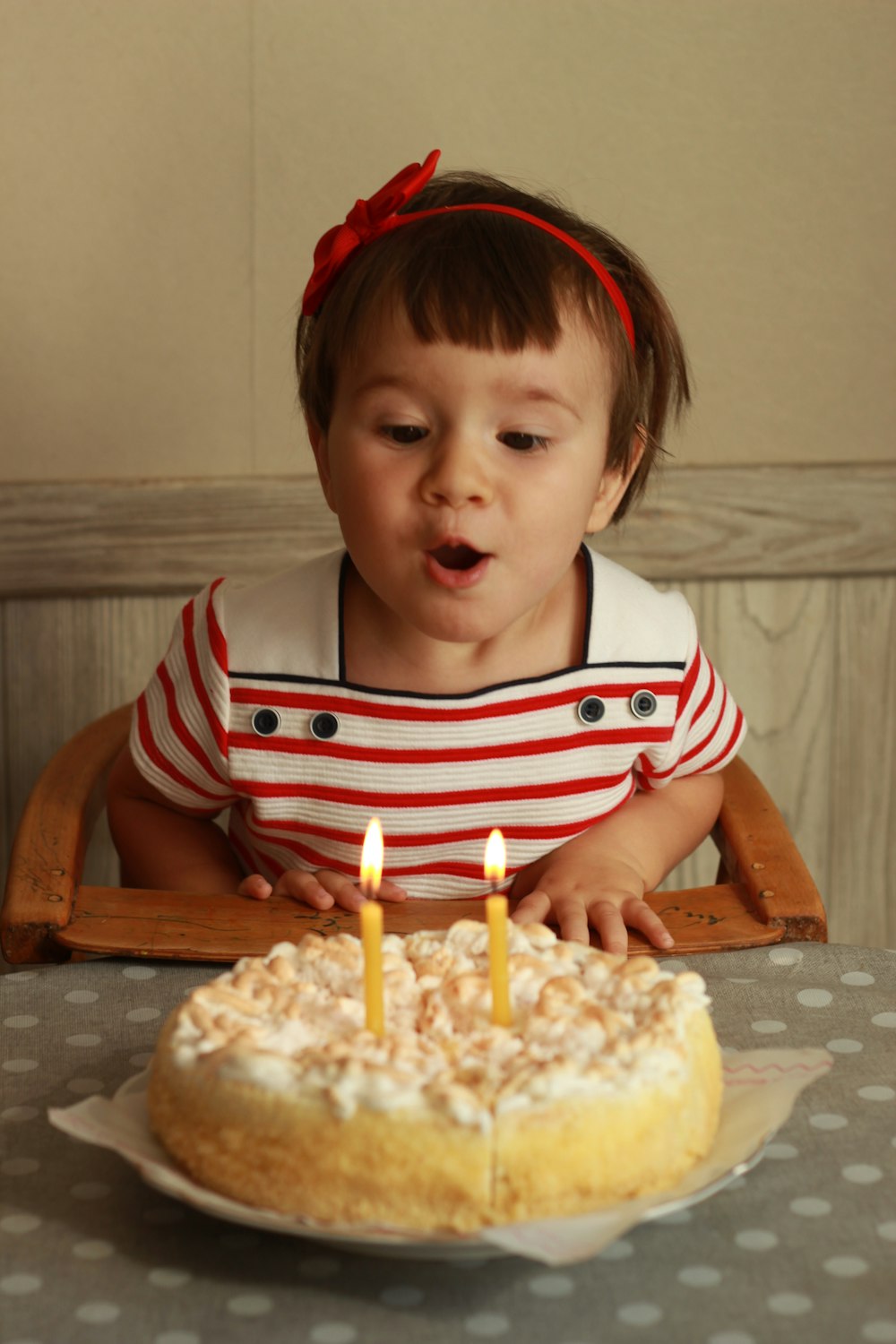 boy in red and white striped shirt sitting on brown wooden chair