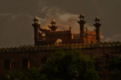 A beautifully decorated royal wedding mandap set against the historic fort backdrop at sunset.