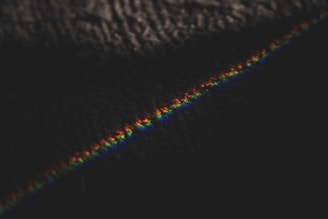 Close-up detail of a colorful rainbow gradient line incorporated into a clean, monochrome website layout.