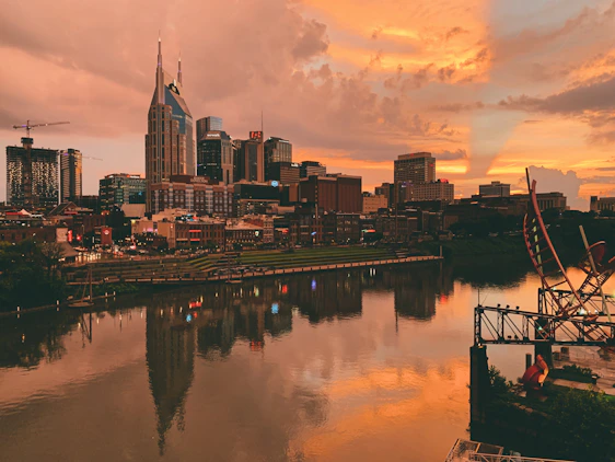 body of water near city buildings during sunset