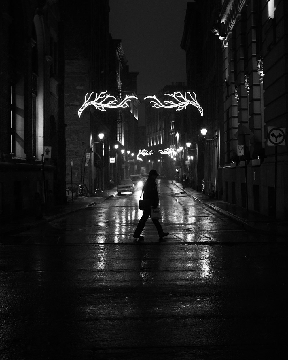 foto in scala di grigi di un uomo che cammina per strada