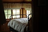 A cozy bedroom with a wooden bed frame and soft linens.