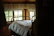 Cozy bedroom featuring a solid wood bed frame with soft natural light streaming through a window.