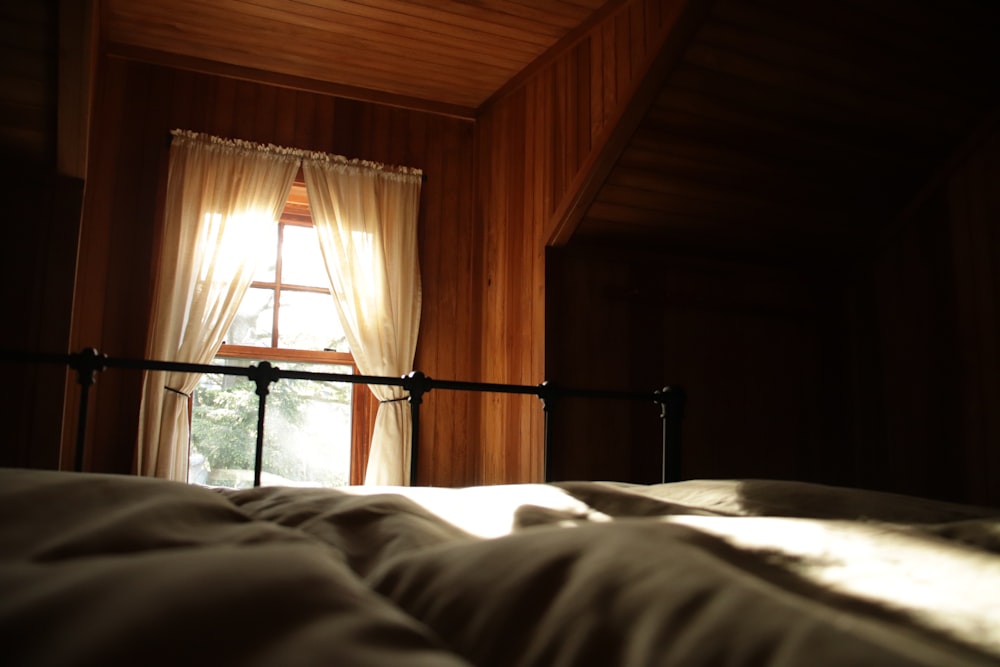 white bed linen near black metal bed frame