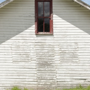 red wooden window on white wooden house