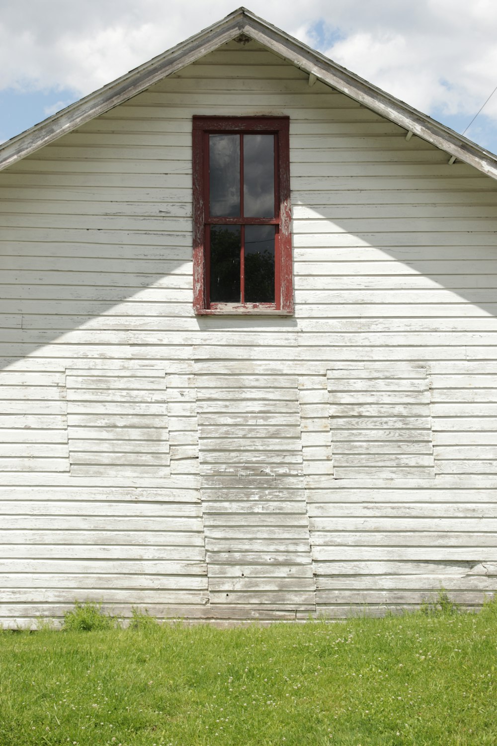 rotes Holzfenster auf weißem Holzhaus