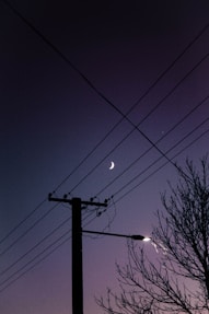 black electric post under blue sky during night time
