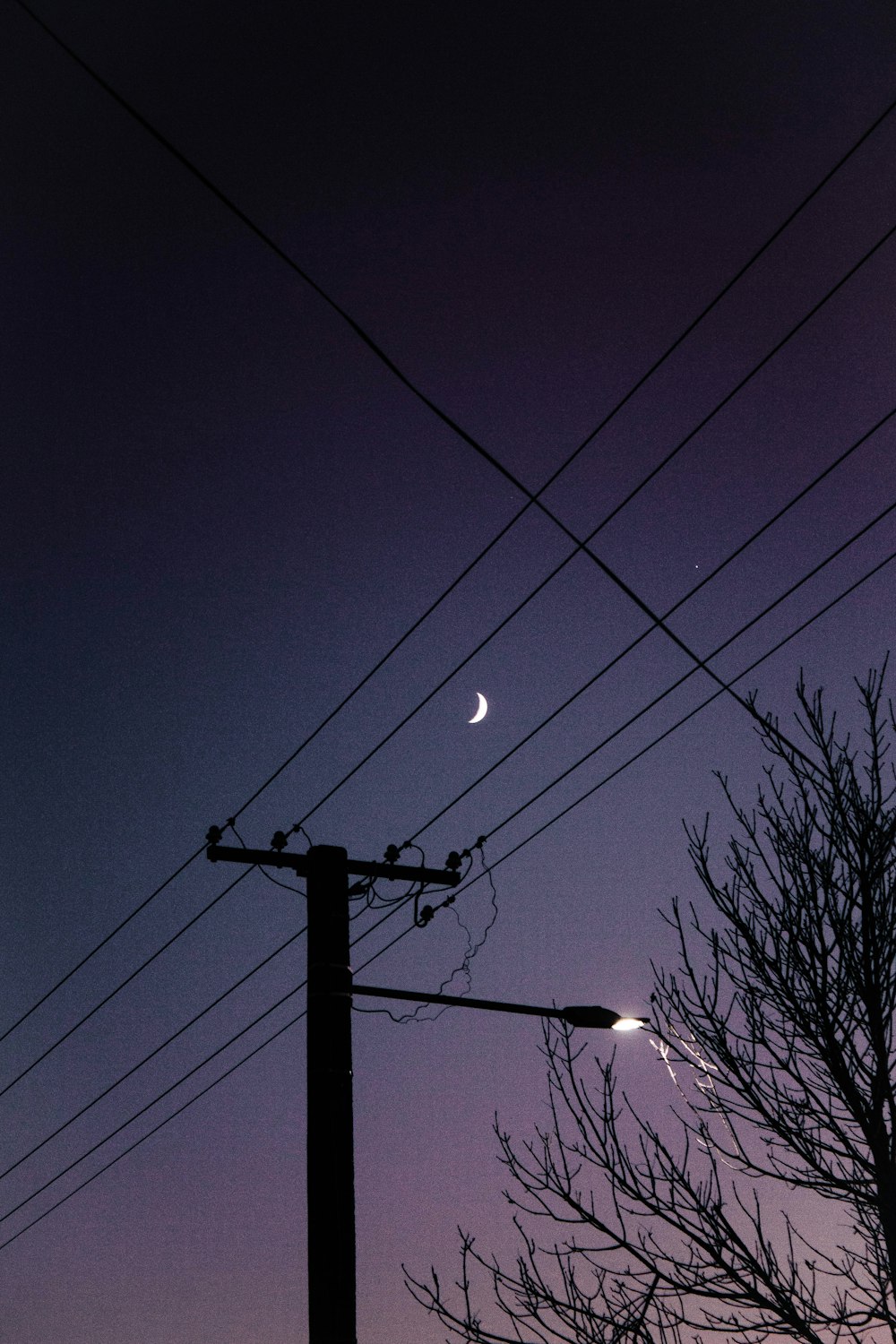 black electric post under blue sky during night time