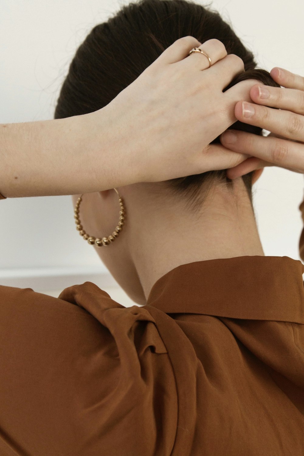 woman in brown shirt wearing white pearl bracelet