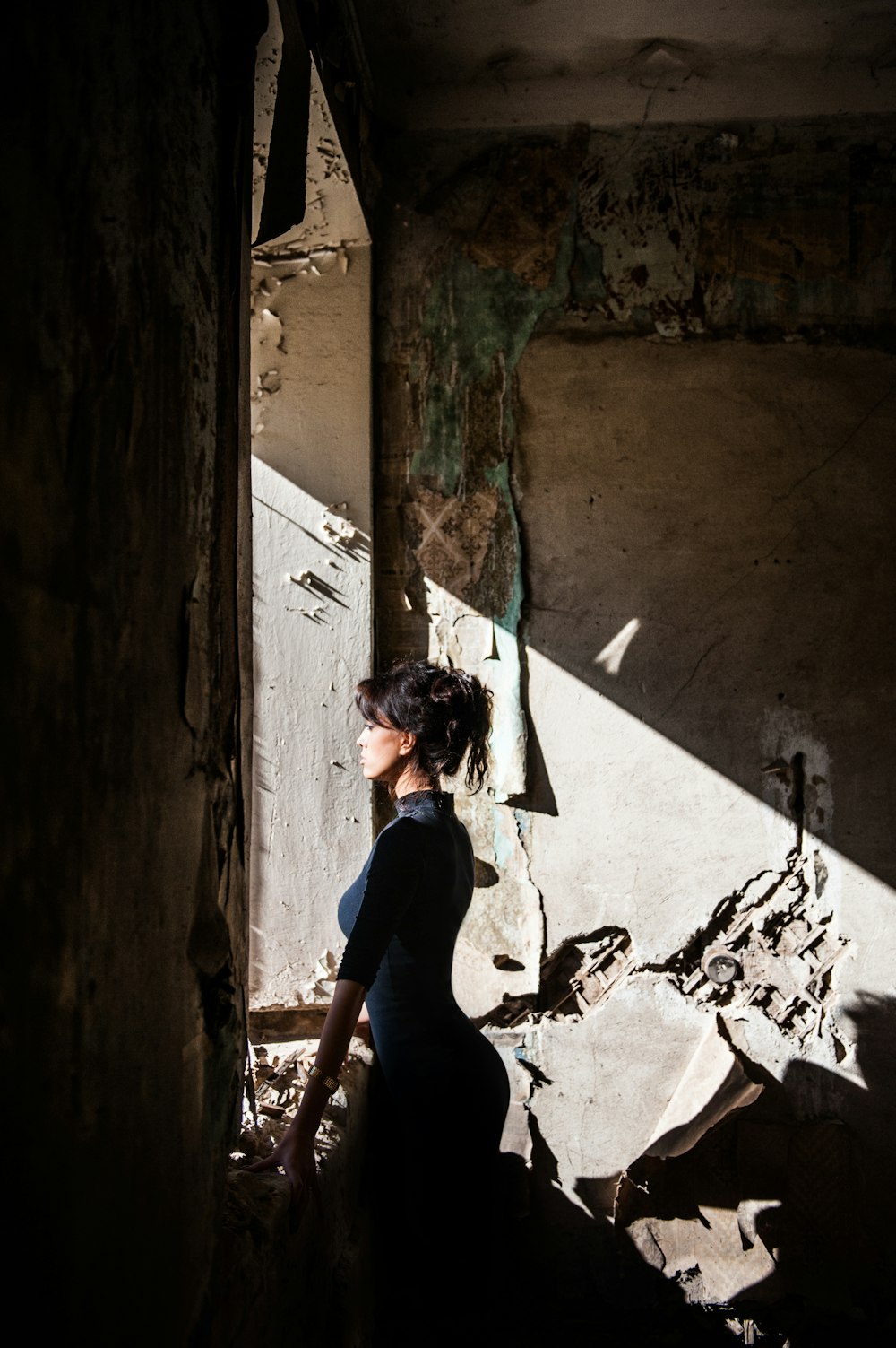 woman in black shirt standing beside wall