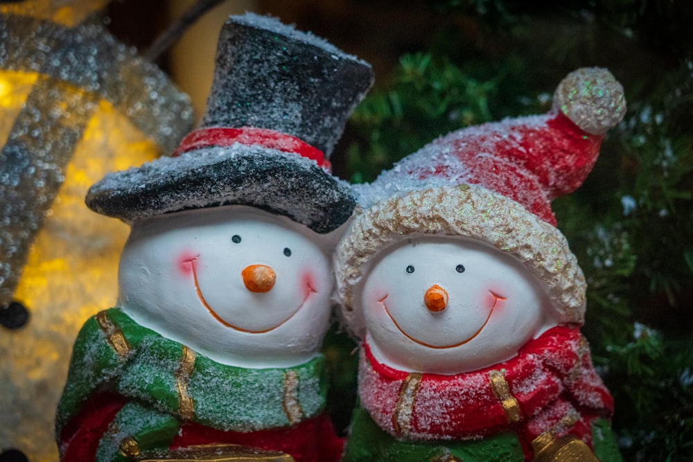 two snowman wearing red and blue scarf