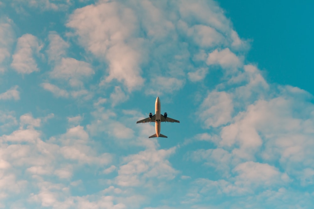 aeroplano bianco che vola nel cielo durante il giorno