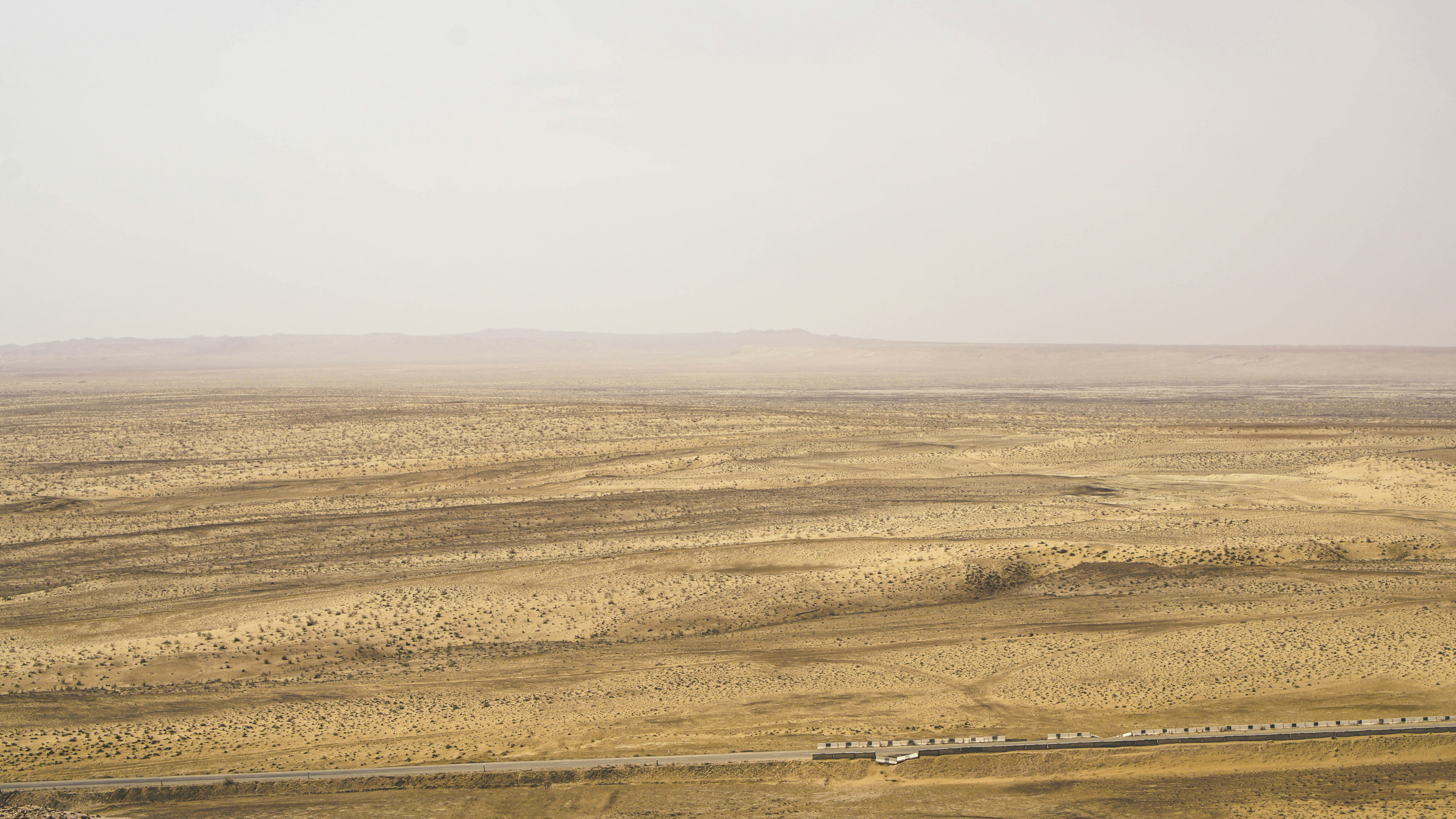 brown field under white sky during daytime