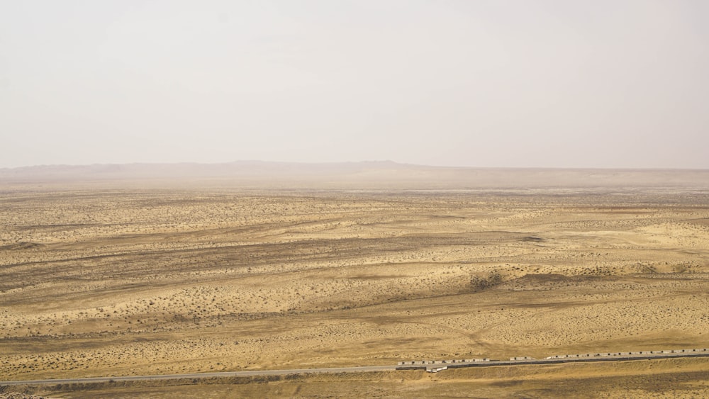 campo marrone sotto il cielo bianco durante il giorno