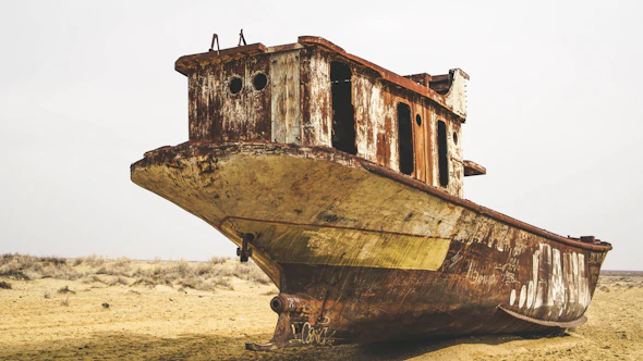 brown and white boat on brown sand during daytime