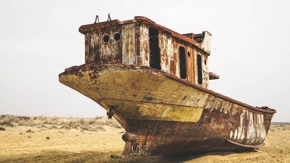 brown and white boat on brown sand during daytime