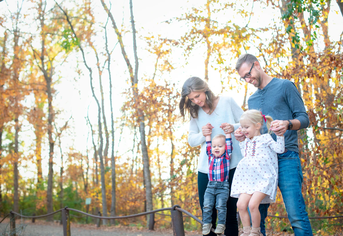 Parents walking with their young children in an autumn park