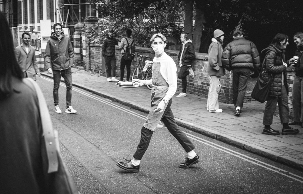 man in white long sleeve shirt and black pants walking on pedestrian lane