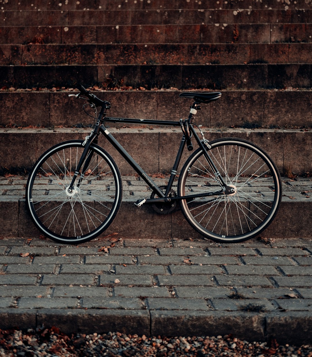 black and gray road bike leaning on brown brick wall
